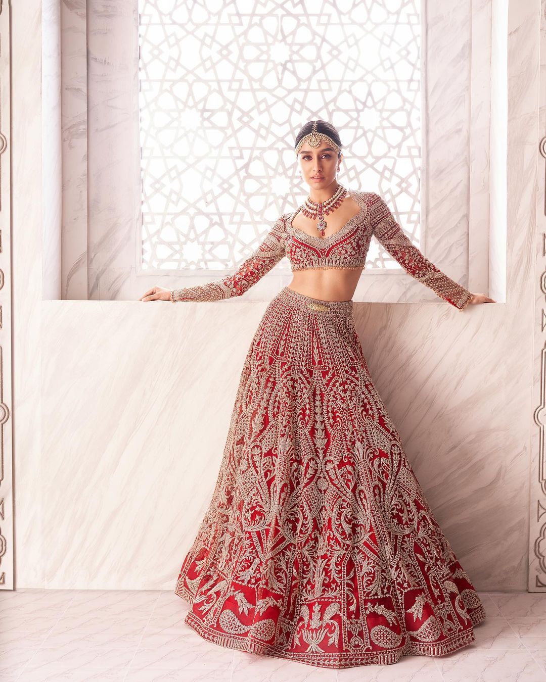 Shraddha is seen in a classic, crimson bridal Lehenga