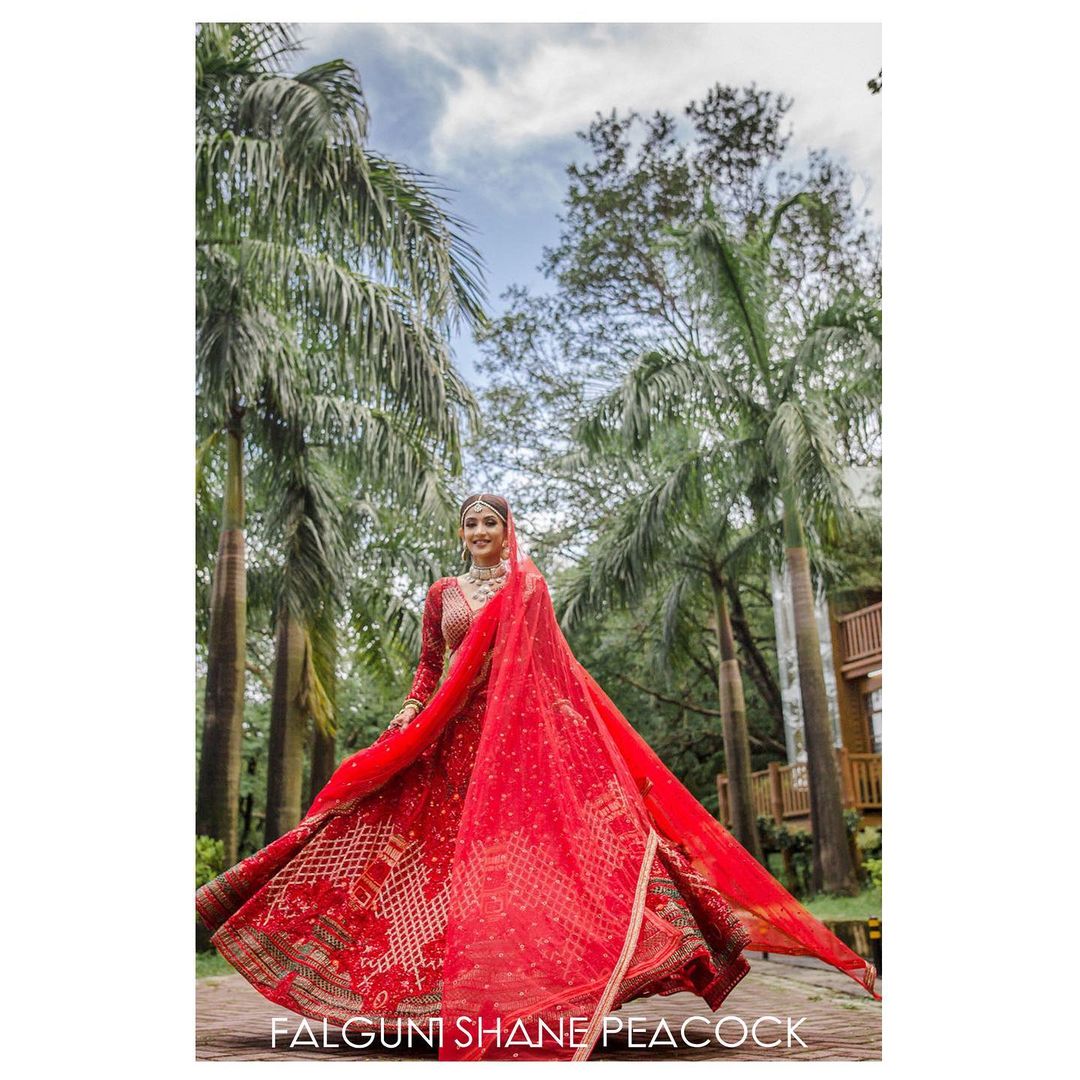 The red bridal Lehenga is teamed with a full-sleeved blouse