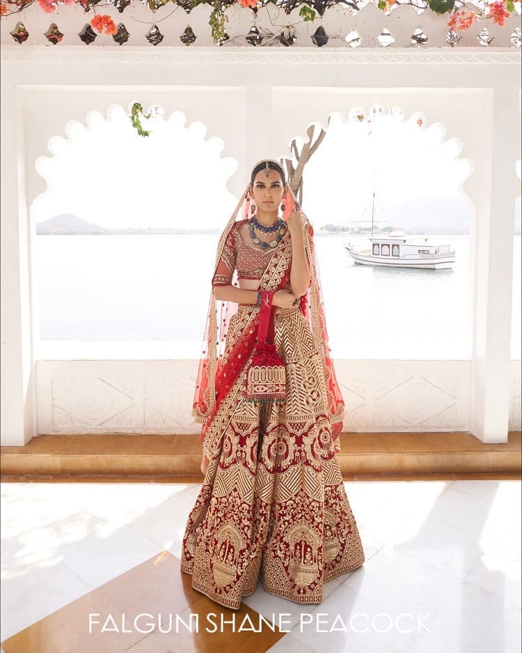 Mon Amour Jag Niwas, entailing a royal red bridal Lehenga featuring palanquin, chevron, and foliage adornments