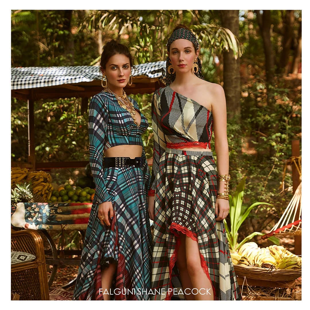A multicolored, one shoulder top, paired with a high-low skirt, is replete with tartan prints