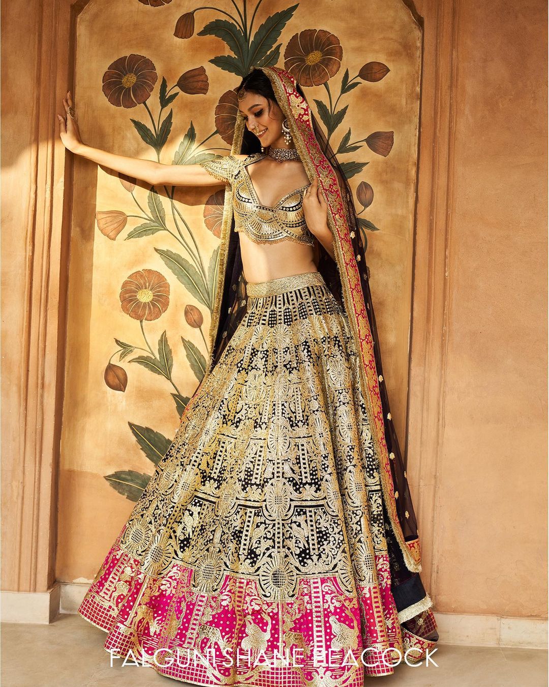 The multicolored, golden chrome applique Lehenga is teamed with a cap-sleeved blouse and a tulle Dupatta