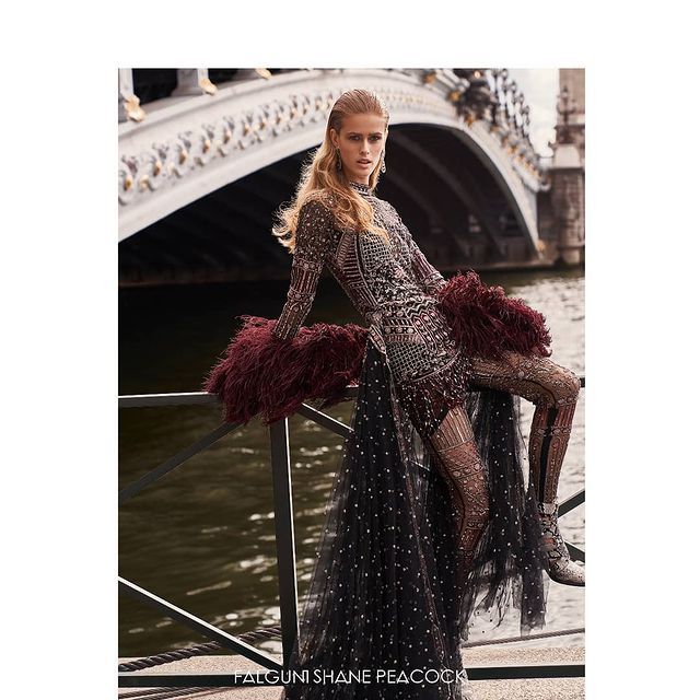 black short dress adorned with crystals and stones and detailed with an extended trail